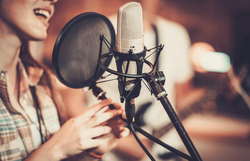 Lekcje śpiewu lub gry na instrumentach - kobieta śpiewająca do mikrofonu